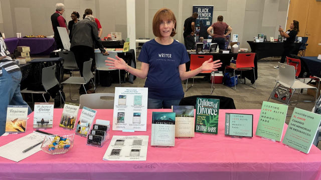Debbie standing behind a table with her books displayed