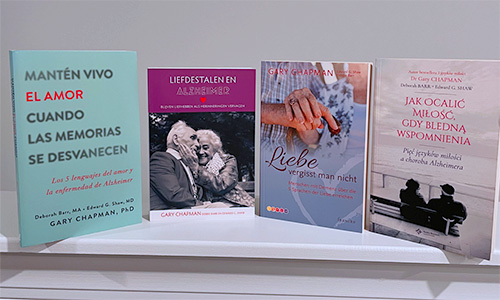 A photo of the foreign language editions of the Keeping Love Alive book in Spanish, Dutch, German, and Polish
